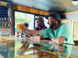 Two people cheering beers